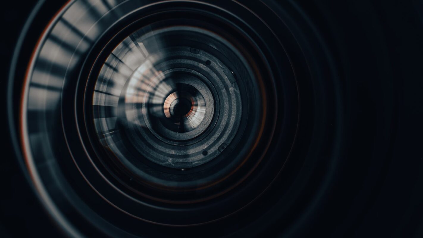 Close up of a camera lens barrel in dark tones representing a look inside the video localization process